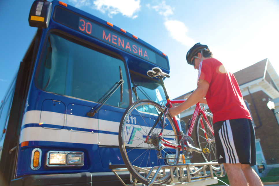 Man putting bike onto bus rack