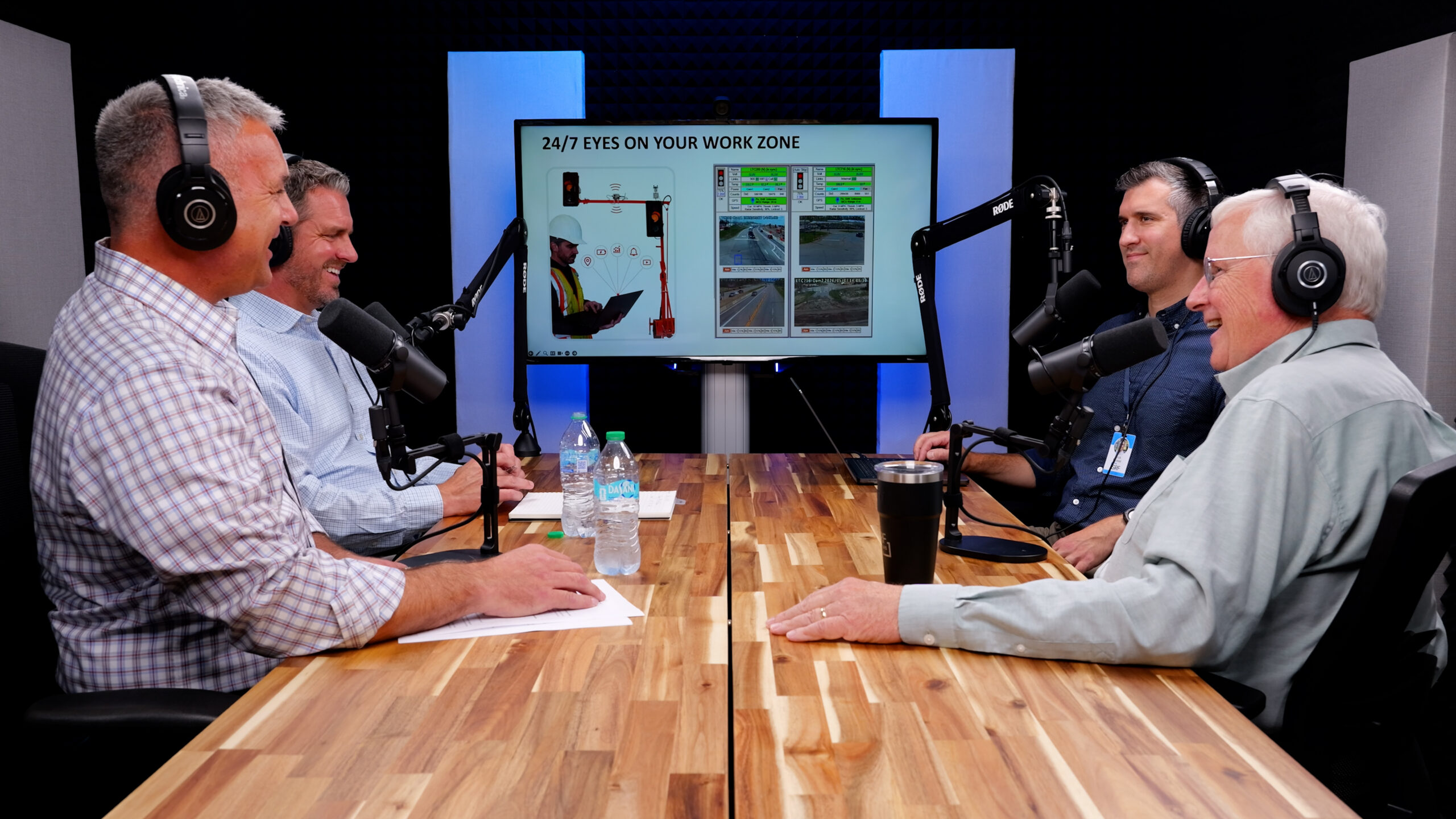 A group of men laugh while recording a podcast episode in the SRF studio.